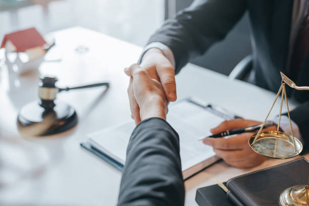 Lawyer and client shaking hands during legal consultation at a law office