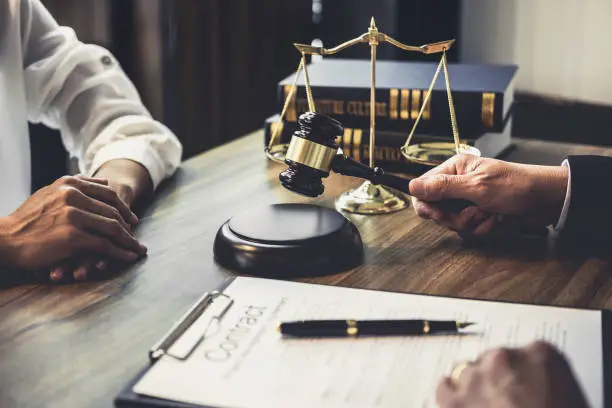 Businesswoman and lawyer meeting at desk with legal documents
