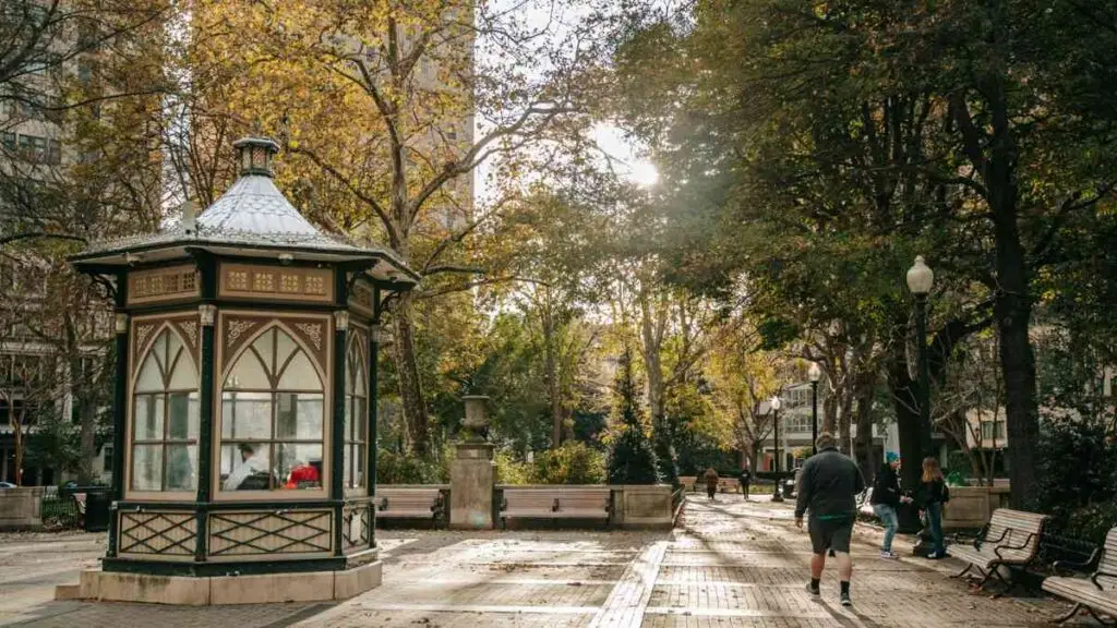 Pedestrians walking through Rittenhouse Square in Philadelphia on a sunny summer afternoon