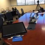 Litigation technology setup in a deposition conference room with monitors, video equipment, and workstations prepared before testimony begins.
